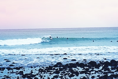 People surf in the daytime
